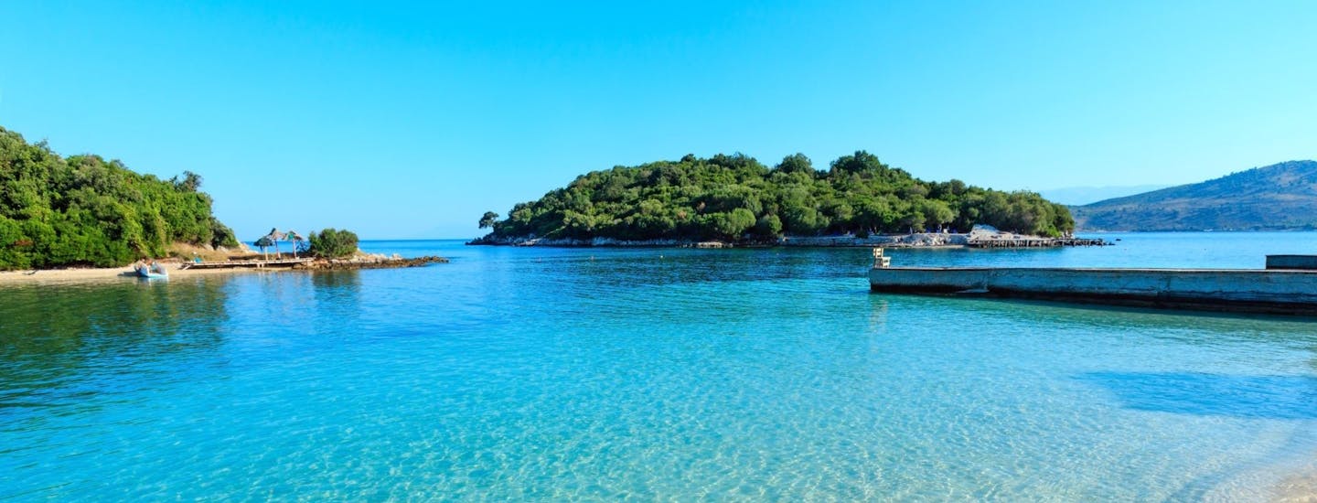 Strand, sol og blått vann i Albania